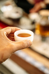 Hand holding Chinese tea cup on traditional tea ceremony