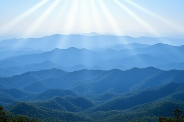 Obraz premium Serene mountain landscape with soft rays of light illuminating peaks.