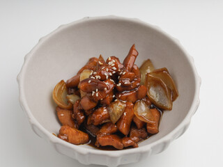 chicken cooked with teriyaki sauce in white bowl on white background