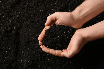Female hands with black soil, closeup