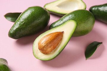 Fresh ripe avocados on pink background