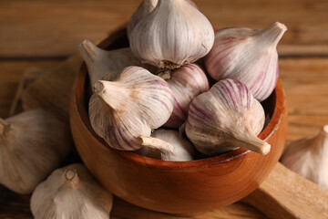 Bowl with fresh garlic on wooden background, closeup