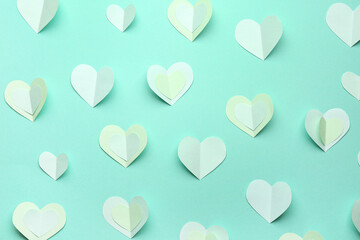 Many paper hearts on turquoise background. Valentine's Day celebration