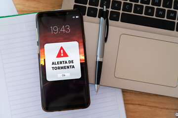 Smartphone with emergency notification about an incoming storm. 