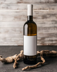 Blank white label mock up on black bottle of unlabeled wine on a table. Alcohol bottle mockup...