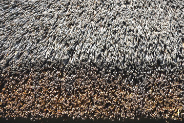Close-up of an old straw thatched roof. Weathered thatched roof texture
