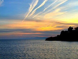 Dusk sky clouds over calm ocean water 