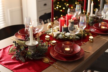 Christmas place setting with festive decor on wooden table in room