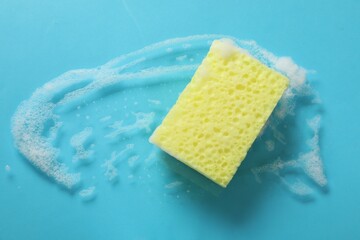 One cleaning sponge and foam on light blue background, top view. Space for text