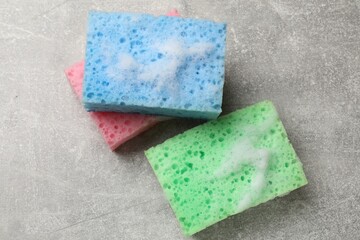 Sponges and foam on light grey table, flat lay