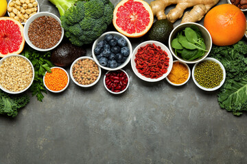 Superfood. Different healthy food products on grey table, flat lay. Space for text