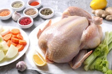 Fresh raw turkey and different products on gray textured table, closeup