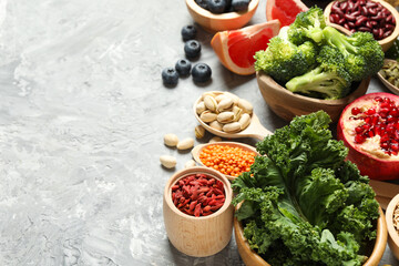 Different superfood products on grey textured table. Space for text