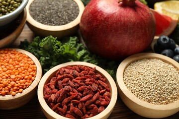 Different superfood products on wooden table, closeup