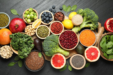 Different superfood products on black table, flat lay