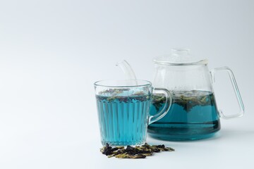 Fresh butterfly pea flower tea and dry petals on white table. Space for text