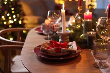 Beautiful dishware and Christmas lights on wooden table indoors, closeup