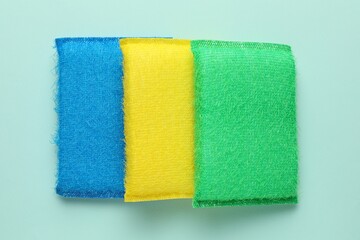 Color sponges on light blue background, top view