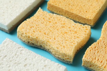 Many sponges on light blue background, closeup