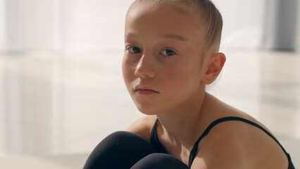 Caucasian little girl dancer gymnast pensive sad looking at camera offended frustrated adopted...