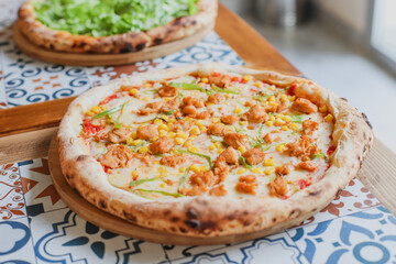Hot tasty traditional various italian pizzas with salami, meat, cheese, onion, mushroom, tomatoes greens on a dark background