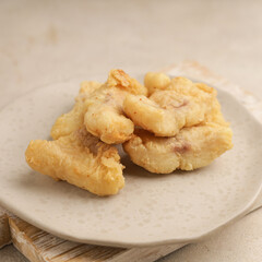 Fried fish nugget on white plate and white background