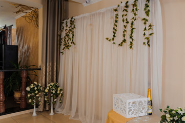 Elegant Event Decoration with Draped Curtains and Floral Arrangements