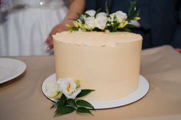 Elegant Creamy Wedding Cake Adorned with Fresh Flowers and Pearls