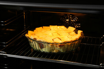 Baking dish with raw homemade apple pie in oven