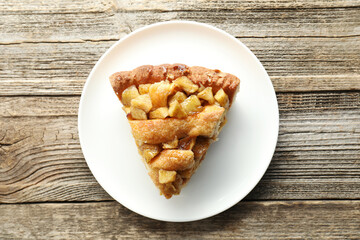 Slice of homemade apple pie on wooden table, top view