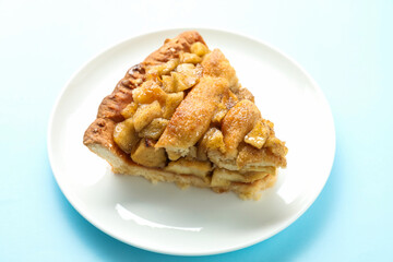 Slice of homemade apple pie on light blue background, closeup