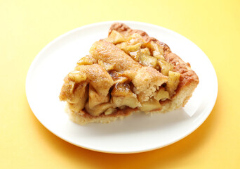Slice of homemade apple pie on orange background, closeup