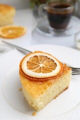 Slice of tasty semolina cake served on white table, closeup