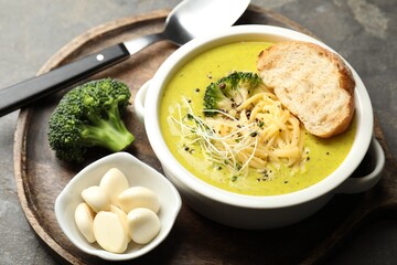 Delicious broccoli cream soup served on gray table, closeup