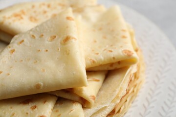 Tasty thin crepes on plate, closeup view