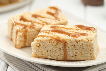 Delicious caramel puffed rice bars on table, closeup