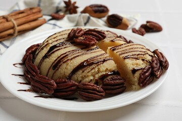 Delicious sweet semolina halva with pecans on white tiled table, closeup