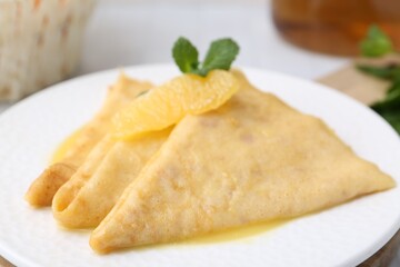 Tasty crepes Suzette on plate, closeup. French cuisine