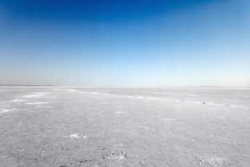 Surface of the lake covered with snow or salar. Landscape of a deserted salt lake or plains. texture of salt formations in the foreground. salt lake surface, dry salt lake