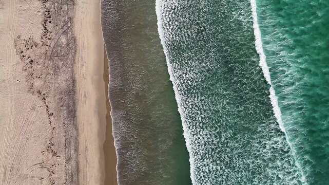 Aerial footage of the pacific ocean waves rolling on Coronado Beach in Coronado, California, USA