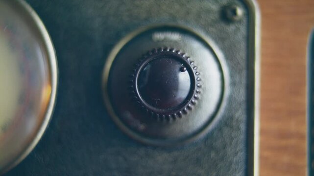 Closeup of a hand turning old vintage radio volume button
