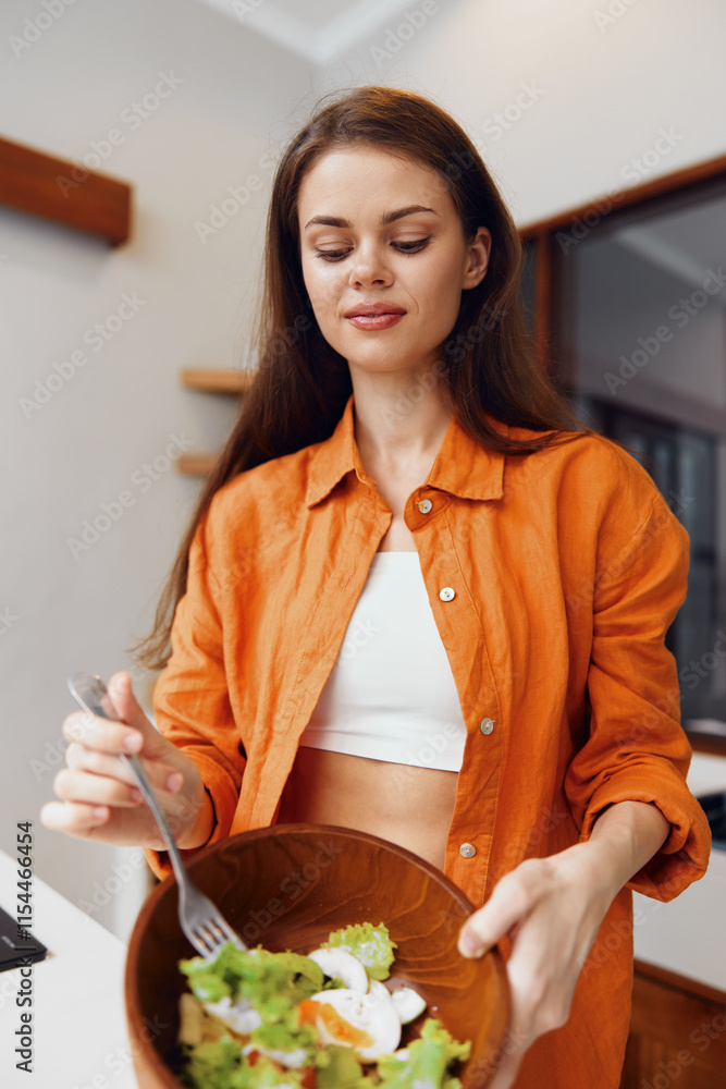 Wall mural Young woman preparing a fresh salad in a bright kitchen, showcasing healthy eating and vibrant colors with a cheerful expression, perfect for health and wellness themes