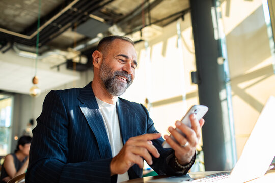 Professional businessman drinking coffee while working on laptop in cafe