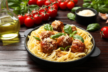 Delicious pasta with meatballs and ingredients on wooden table, closeup