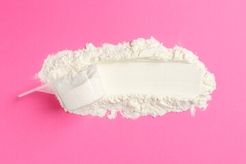 Protein powder and scoop on pink background, top view