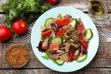 Delicious fresh tuna salad and ingredients on wooden table, top view