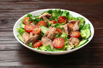 Delicious fresh tuna salad on wooden table