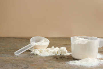 Protein powder and scoops on grey textured table