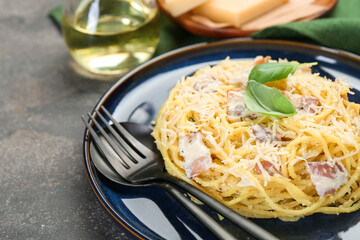 Plate with delicious pasta Carbonara and cutlery on grey textured table, closeup. Space for text