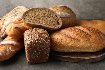 Different freshly baked bread loafs on grey table, closeup